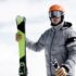 Man wearing helmet and ski goggles holding skis, portrait